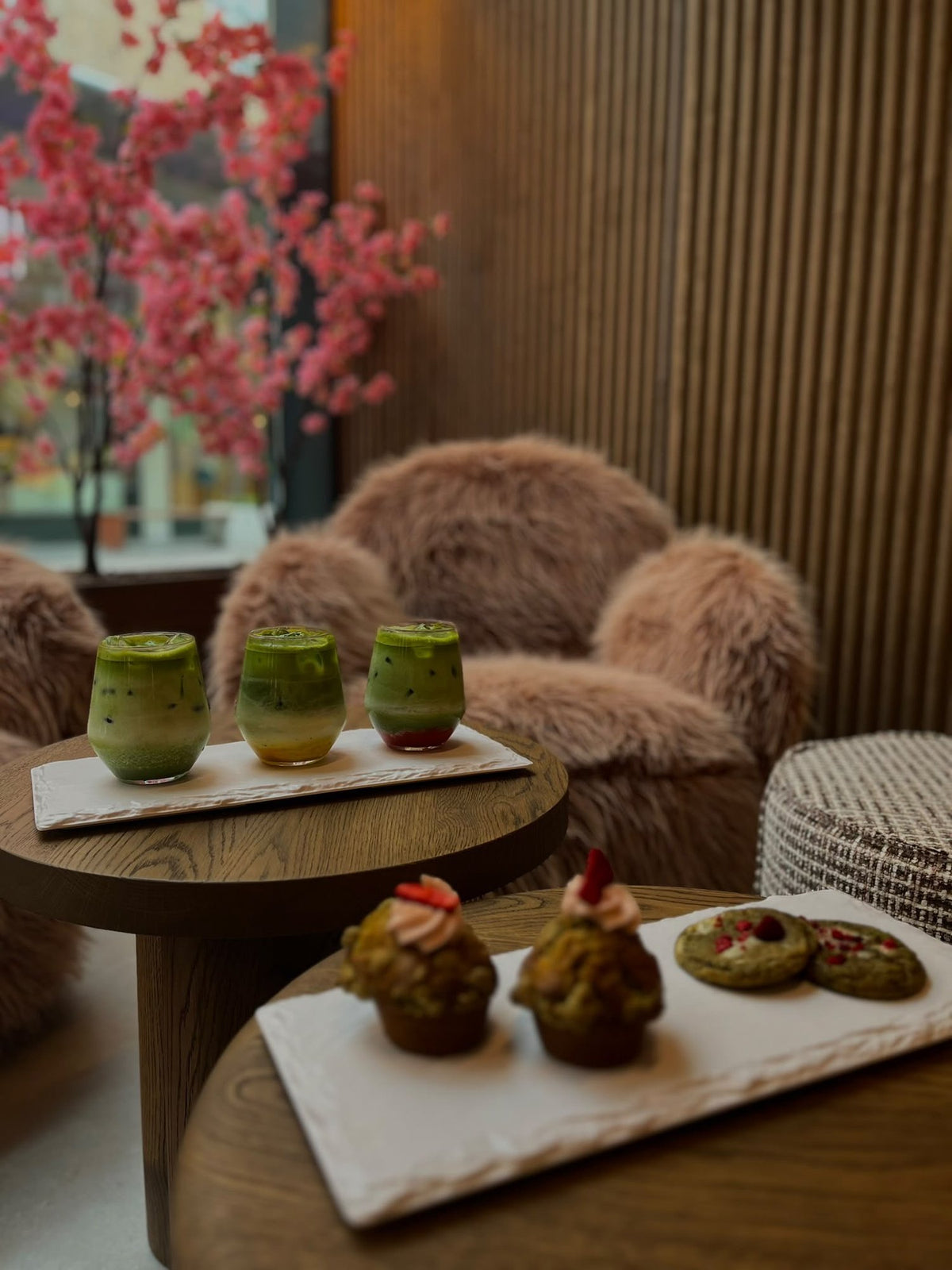 Interieur van AORA Café met een matcha-flight en gebak op een tafel